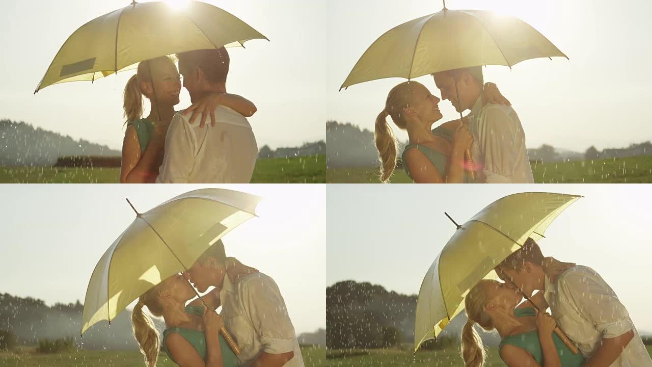 慢动作: 可爱的年轻夫妇在清新的夏雨中微笑和亲吻。