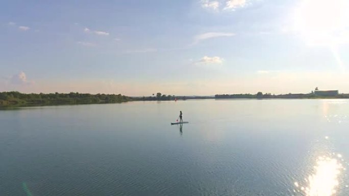 空中女子站立划桨登上湖面