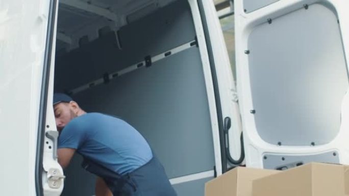 坚强的集中送货员用纸板箱装载货车。