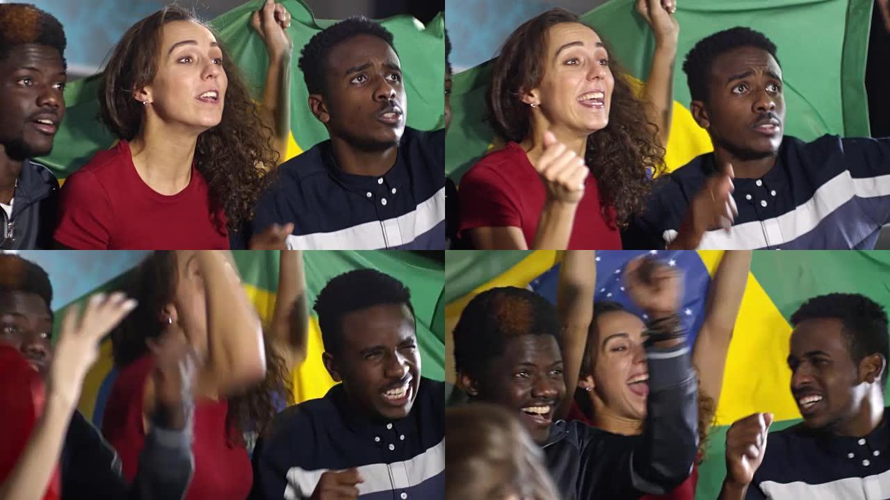 巴西队的球迷在电视上观看足球并举着旗帜