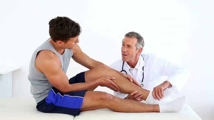 成熟的医生触摸运动员受伤的脚踝