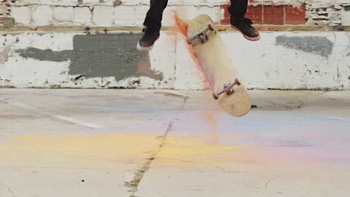 滑板手在慢动作中使用彩色粉末进行极端翻转技巧