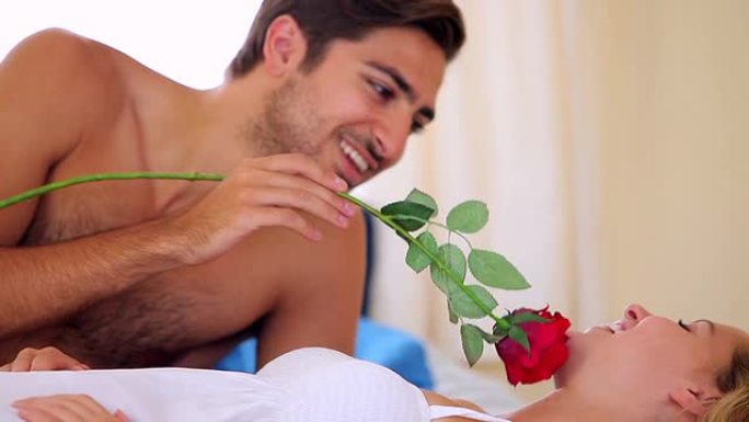 男人在床上用玫瑰挠痒痒