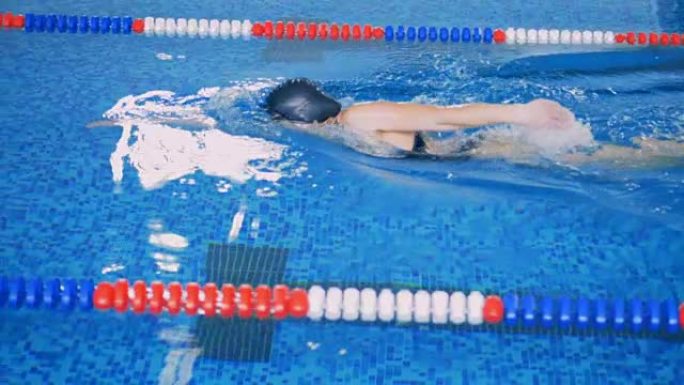 展示爬行动作的女游泳运动员的侧视图。
