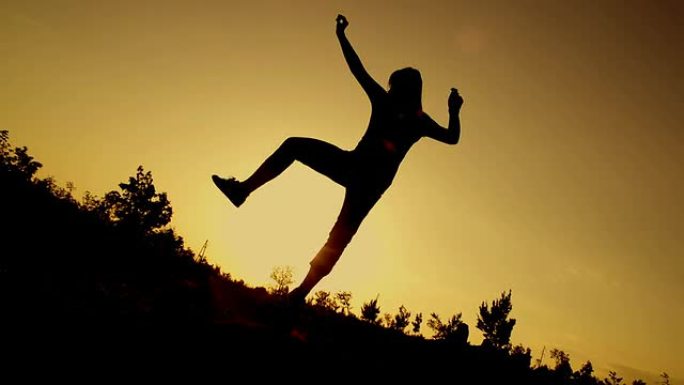 慢动作: 年轻女子在日落时做有趣的跳跃