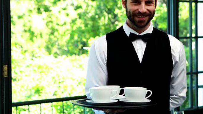4k餐厅的男服务员拿着带咖啡杯的托盘