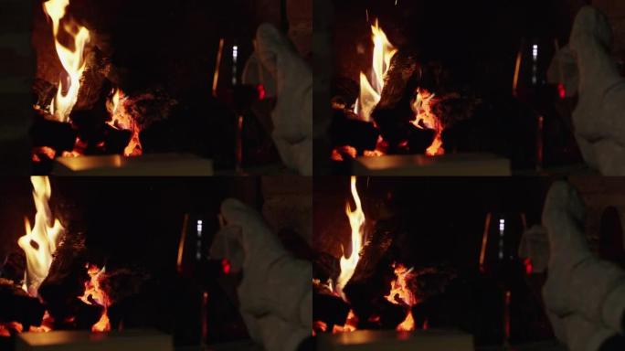 穿着袜子的4k女人在舒适的壁炉旁用红酒放松，慢动作