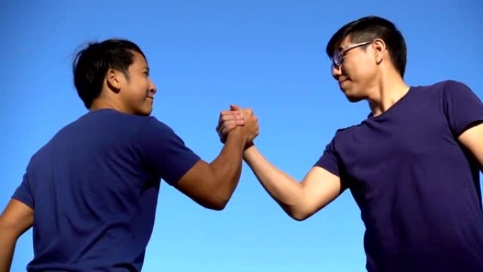 慢速MO CU两名亚洲男子双手进行运动摔跤握手