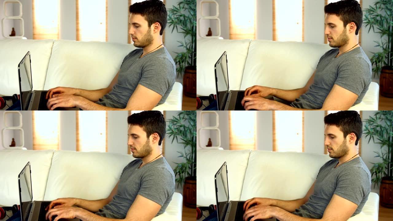 男人在沙发上使用笔记本电脑