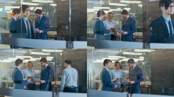 使用平板电脑，由男女外交官和商人组成的团队交谈。高级公司大楼。