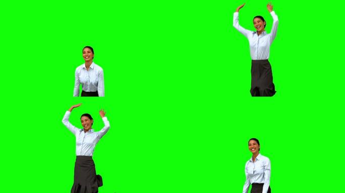 快乐的女商人在绿色屏幕上举起手臂