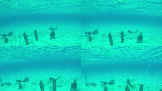水下: 年轻女子在阳光明媚的暑假中，在热带岛屿泻湖海底沉没的佛像保护区周围游泳