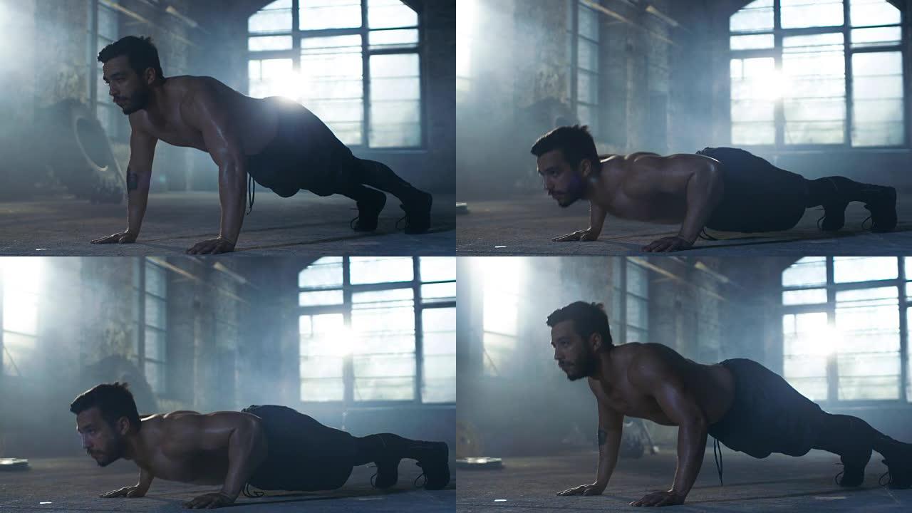 肌肉裸男满身汗水在一个废弃的工厂改造成健身房做俯卧撑。这是他的健身锻炼/高强度间歇训练的一部分。