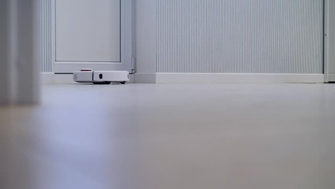 自动无线机器人清洁器在白色房间中工作。