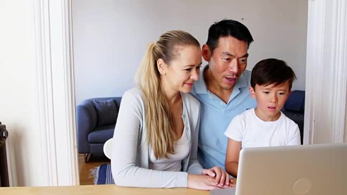 在客厅使用笔记本电脑的幸福家庭