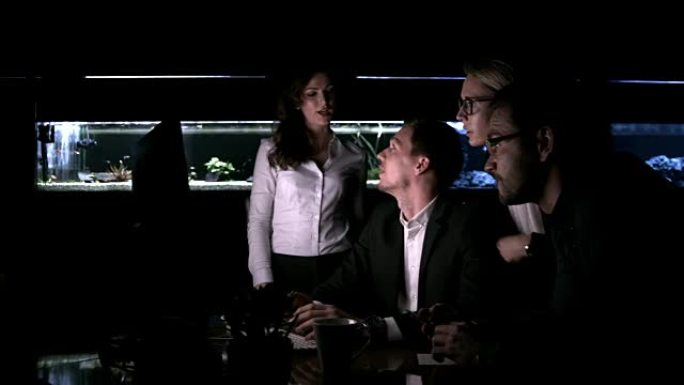 专职商务人员在办公室的计算机上工作到很晚，带鱼缸，实时