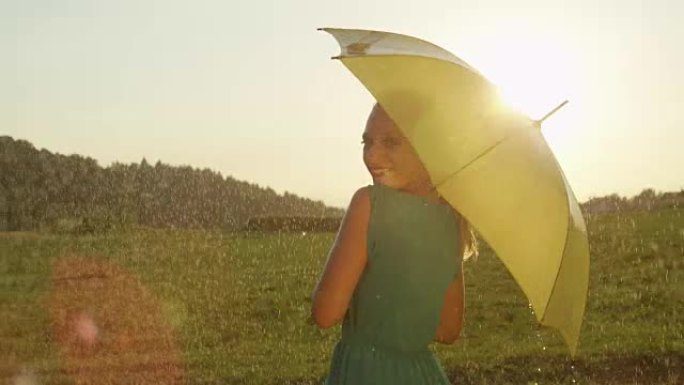 镜头耀斑: 迷人的女人拿着雨伞欢快地看着肩膀。