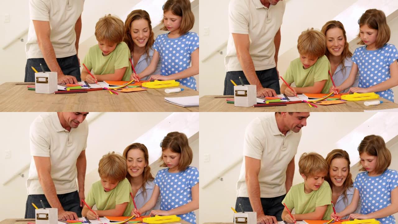 快乐的父母和孩子在餐桌上画画