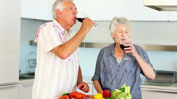 高级夫妇一边喝红酒一边准备健康餐