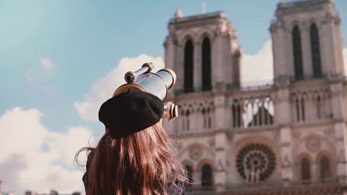 贝雷帽中的女童透过硬币双筒望远镜。慢动作。巴黎圣母院。使用视图望远镜的女学生