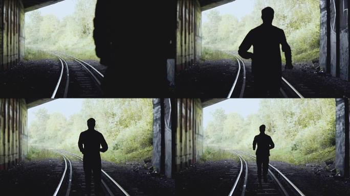 慢动作。在铁路上向前跑的人。后视图。抽象剪影拍摄。追随梦想的概念