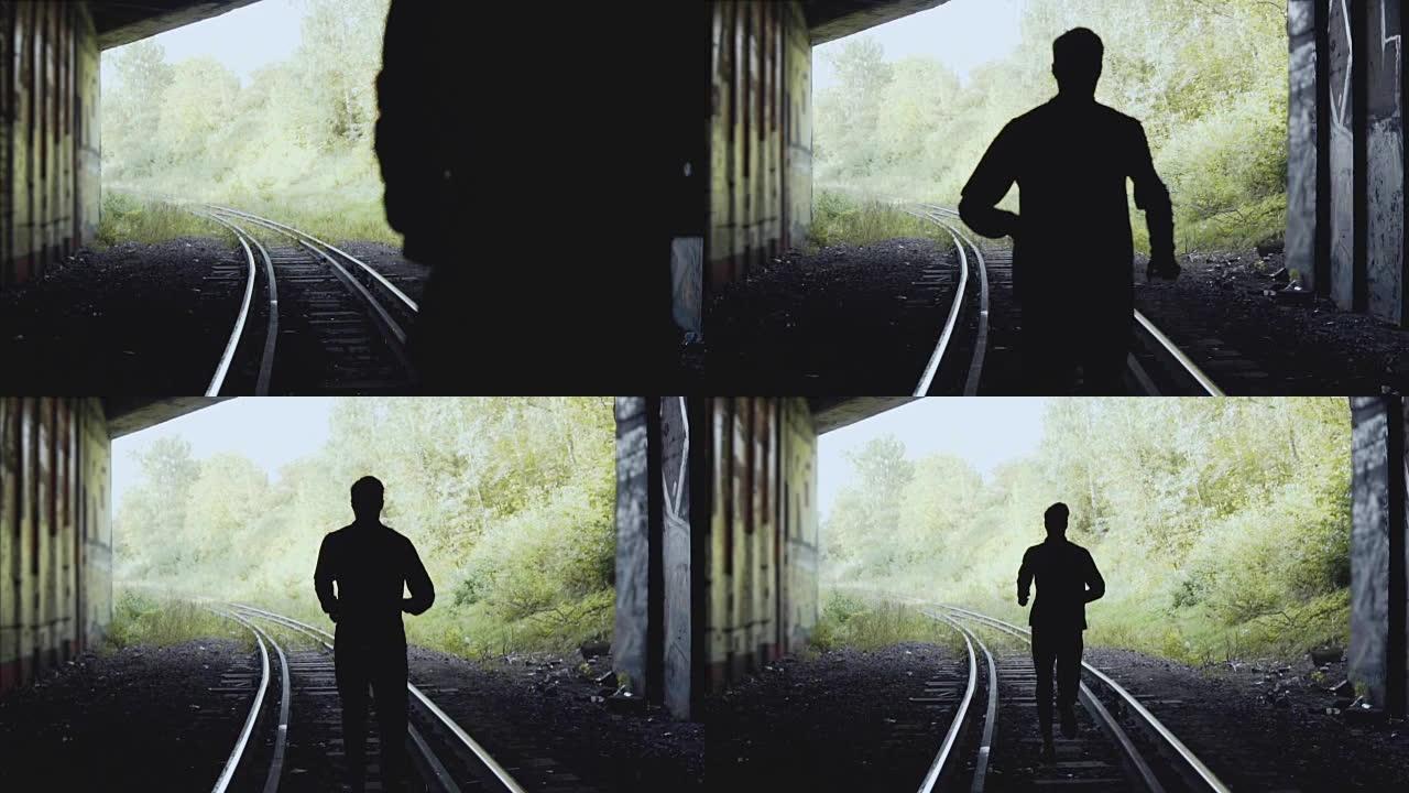 慢动作。在铁路上向前跑的人。后视图。抽象剪影拍摄。追随梦想的概念
