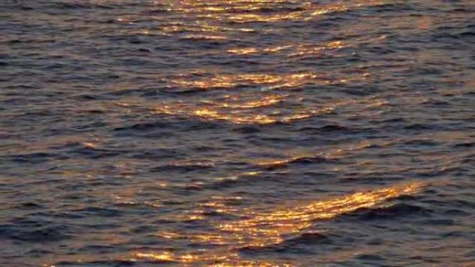 平静的大海中的金色日落倒影。4K, UHD