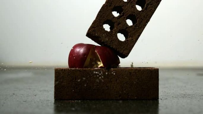 苹果被挤压在两块砖头之间