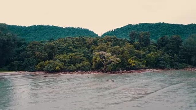 4k空中飞越海滩和美丽的蓝色海洋。热带景观上令人惊叹的日出。