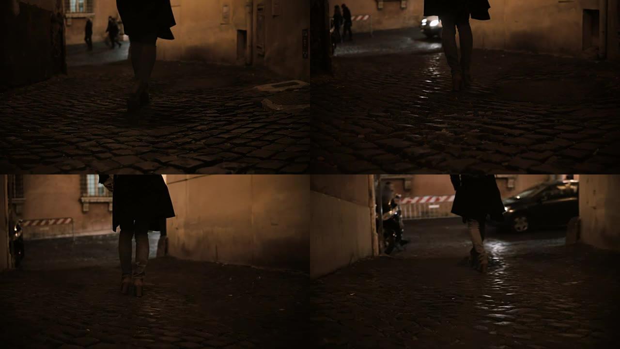 女性脚的特写镜头在晚上穿过人行道，靠近道路上的汽车