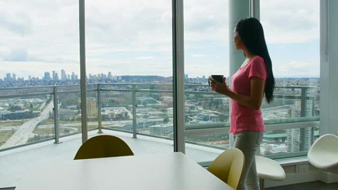 女人在喝咖啡时透过窗户看4k