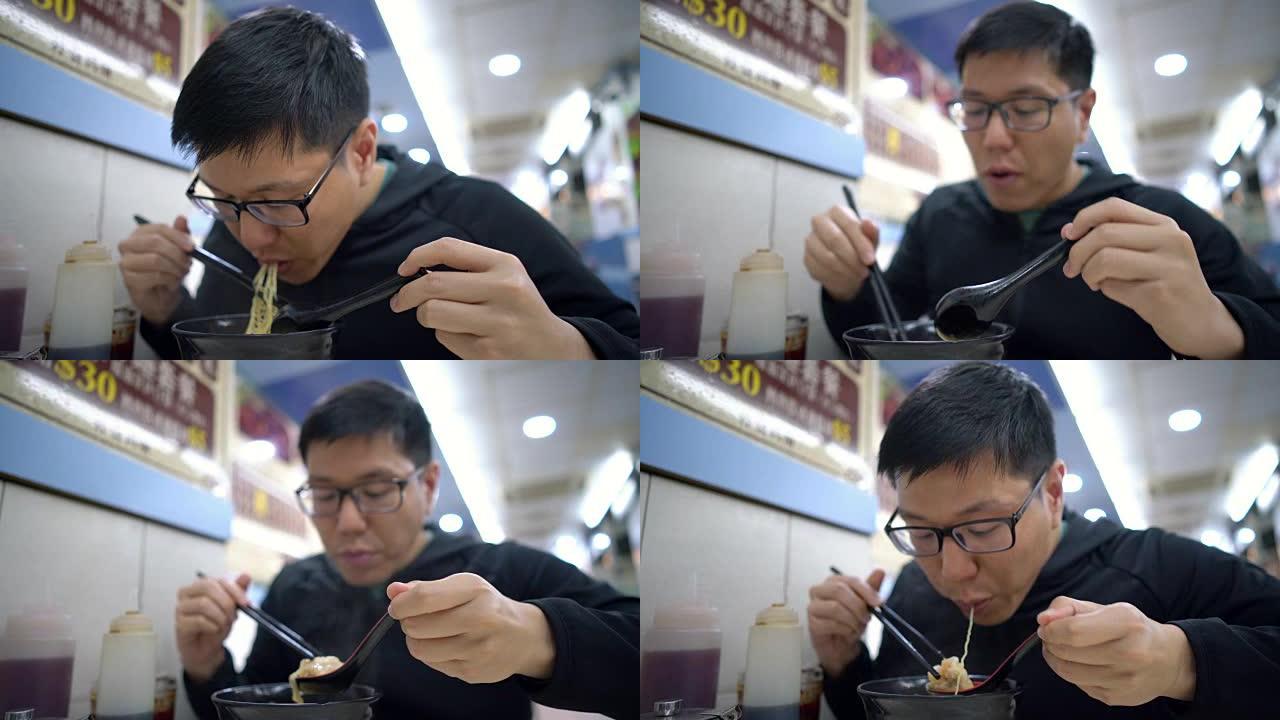 亚洲男子在餐厅吃汤中的香港面条