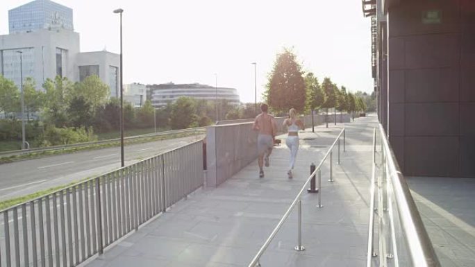 慢动作: 年轻的高加索夫妇在阳光明媚的城市街道上锻炼。