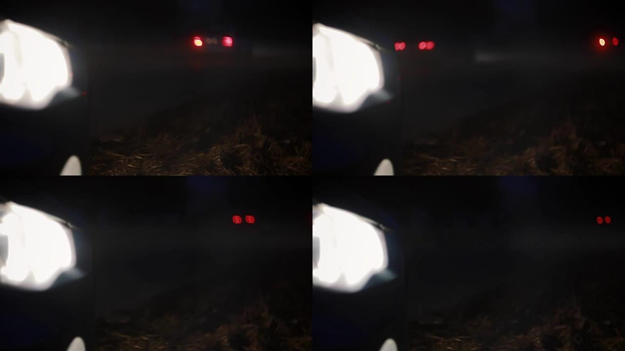 夜间街道汽车前灯的极端特写。模糊的黑暗高速公路，bokeh车灯经过。背景镜头