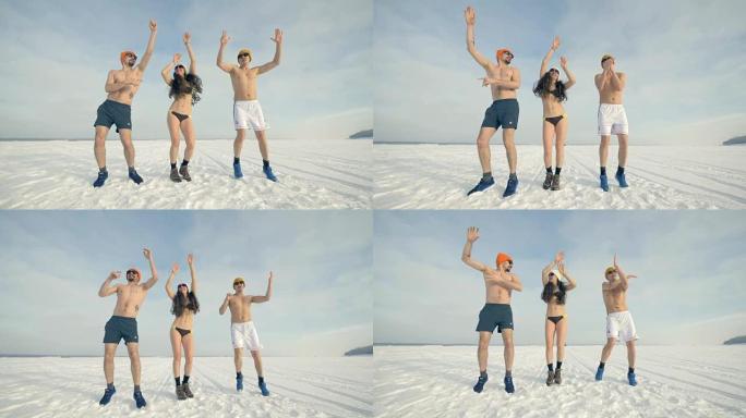 一名妇女和两名男子穿着泳装，双臂在雪地上跳舞。4K。