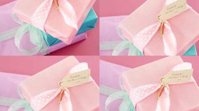 粉色背景下带有母亲节快乐标签的礼品盒