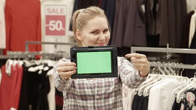 卖家在商场展示绿屏的平板电脑