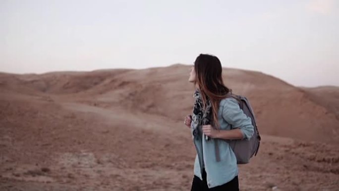 沙漠中欧洲女人的肖像。慢动作。年轻女孩走在沙漠峡谷。生活困难和考验