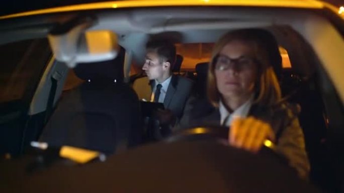 WS商人晚上在豪华轿车的后座上使用平板电脑