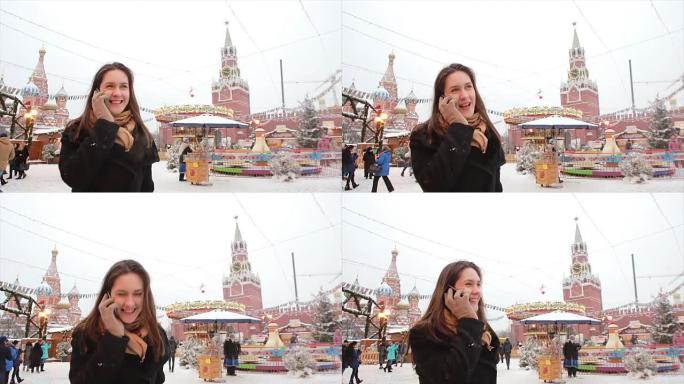 冬天，女人站在莫斯科红场，克里姆林宫和圣巴西尔大教堂前的电话里