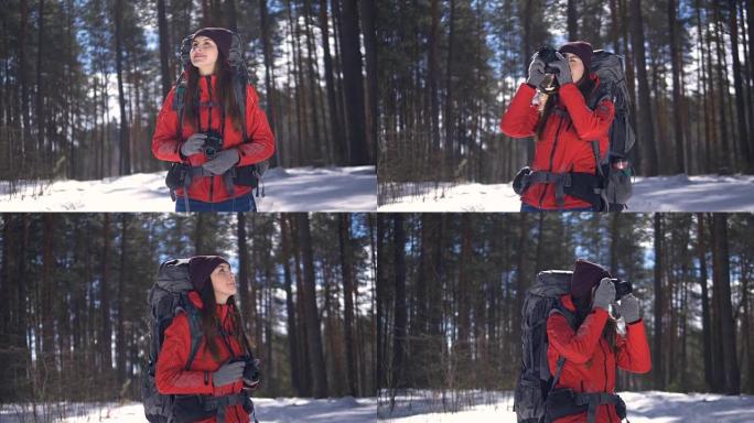 冬天森林里快乐的年轻女子用照相机拍照。