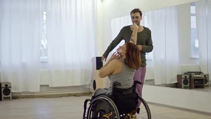 才华横溢的女人与男性编舞在轮椅上跳舞