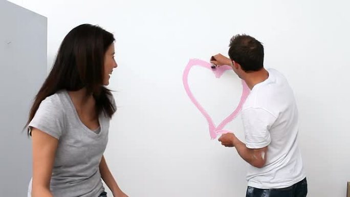 男人在墙上画一颗心