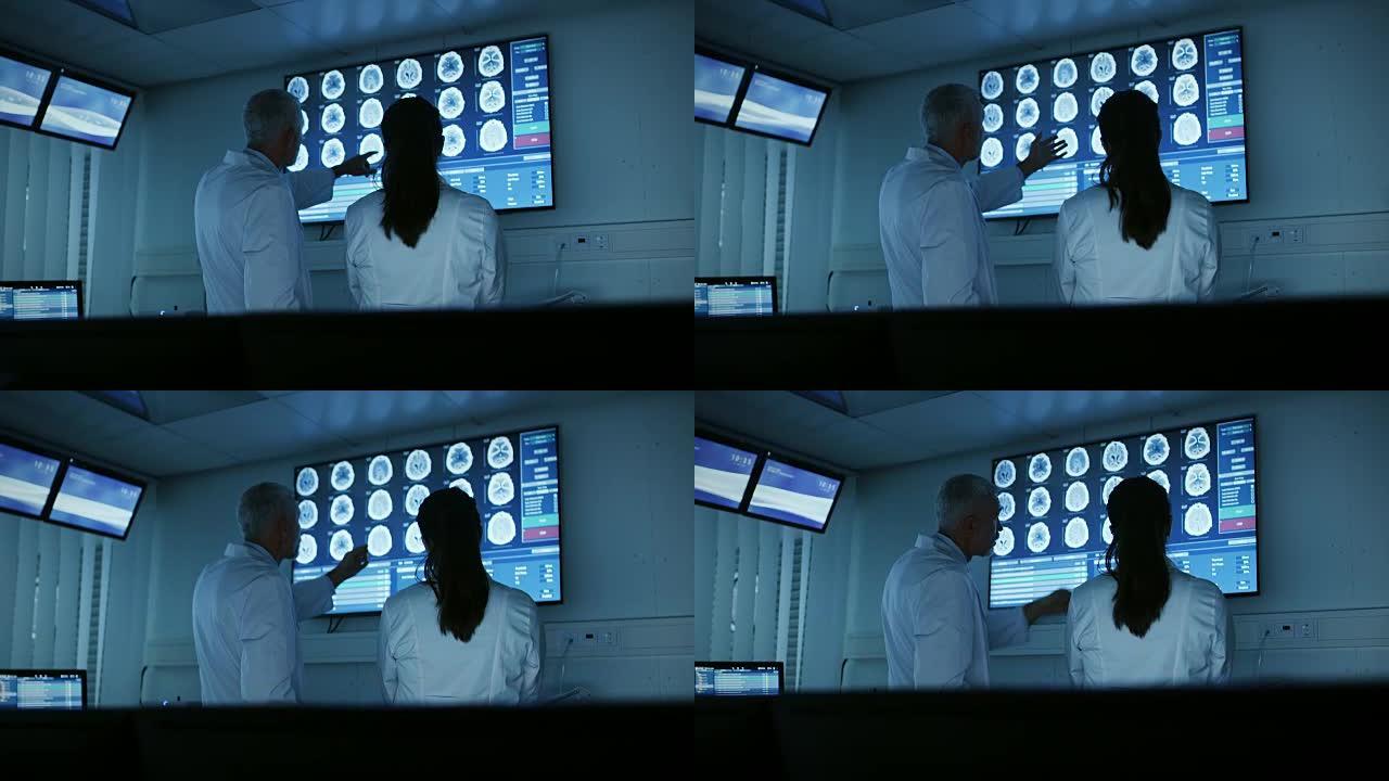 两位医学科学家/神经学家，在现代实验室中交谈并指向墙壁电视，显示CT/MRI脑部扫描。研究科学家在神