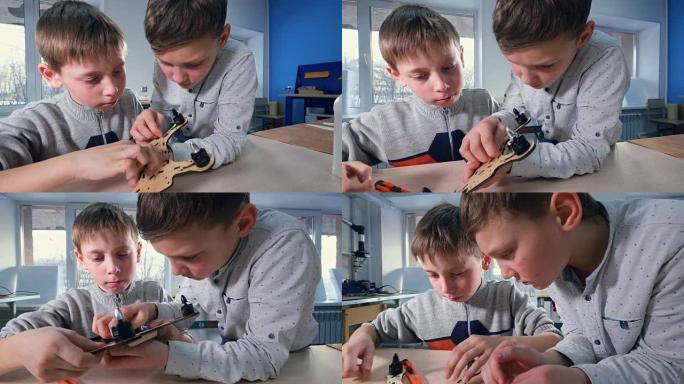 两个男孩正在完成他们的木制无人机模型
