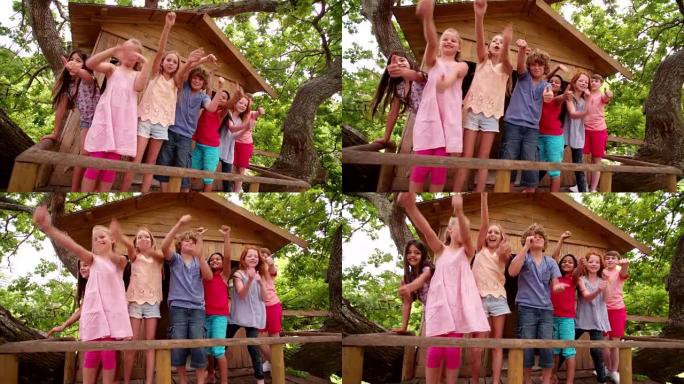 混合种族的儿童从木制树屋中挥舞