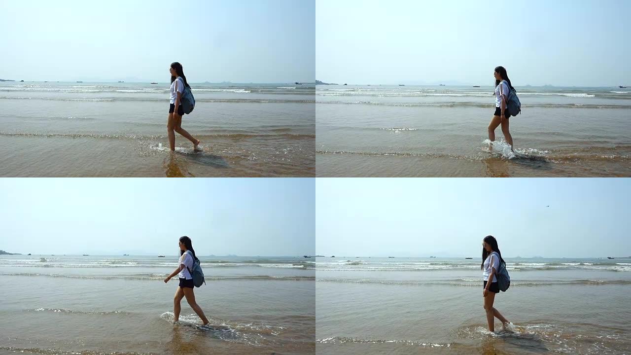 年轻的女游客，背着背包在海边散步，慢动作