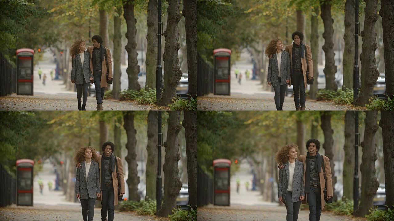浪漫的情侣慢动作走在城市的秋天街上
