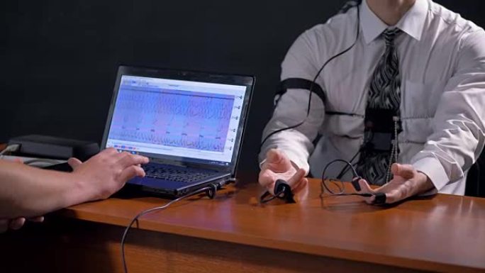 操作员和受试者手旁边的测谎仪计算机屏幕。