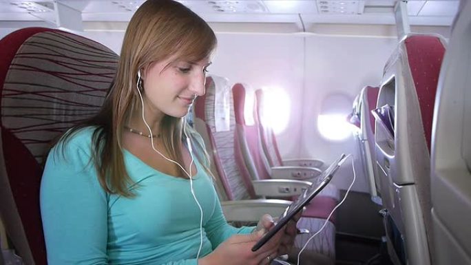 在飞机上使用电子阅读器的女人